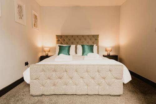 a bedroom with a large white bed with green pillows at The Sun Deck Apartment - Westbrook Bay Beach - By Goldex Coastal Breaks in Margate