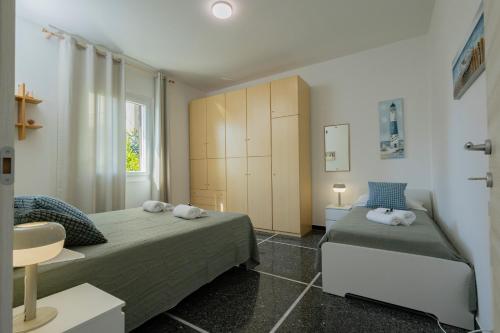 a small bedroom with two beds and a cabinet at "Lomellina Bay" 10 minuti a piedi dal mare in Varazze
