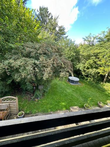 a view of a yard with a picnic table in the grass at Skovbrynet 2 The place for you in Løkken