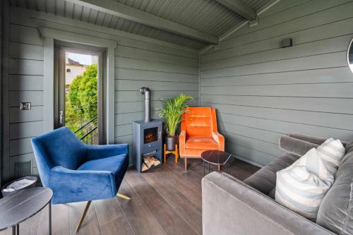 a living room with a couch and chairs and a stove at Gabriel House Guesthouse in Cork