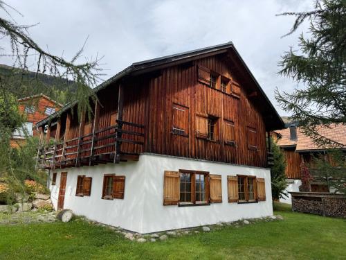 a building with wooden doors and windows in a yard at Casa Seglias in Brigels
