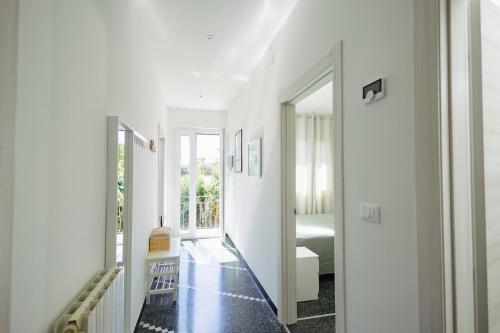 a hallway with white walls and black flooring at "Lomellina Bay" 10 minuti a piedi dal mare in Varazze