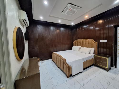Un dormitorio con una cama y una pared de madera. en Divine Hotel Lahore, en Lahore