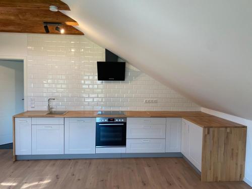 a kitchen with white cabinets and a sink and a staircase at Ferienwohnung Auf der Höhe in Erbach im Odenwald