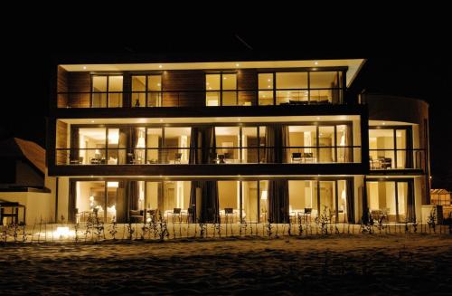 a large building with many windows at night at Hotel Restaurant Spa Torkel in Nonnenhorn