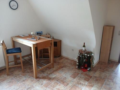 a room with a table and a chair and a bottle of wine at Ferienwohnung am Radweg in Zeitlofs