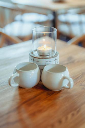 two tea cups and a candle on a table at Strandidyl Bed and Breakfast in Haderslev