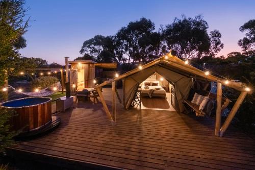a yurt with lights on a deck at night at Scamander Sanctuary Holiday Park in Scamander