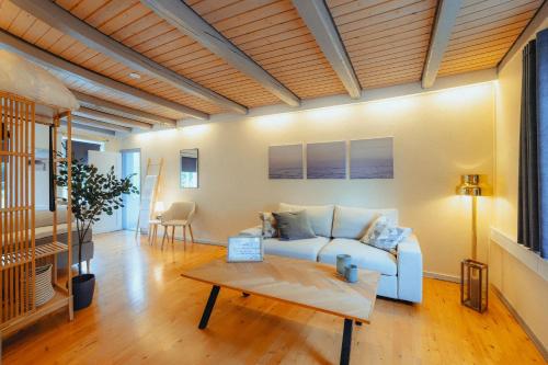 a living room with a blue couch and a table at Strandidyl Bed and Breakfast in Haderslev