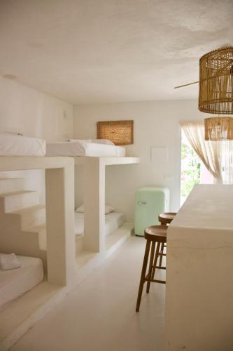 a white bedroom with a bed and a desk at La Pandilla Ibiza in Sant Francesc de s'Estany