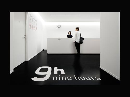 9h nine hours Sendai في سيندايْ: امرأة تقف في مكتب في غرفة بيضاء