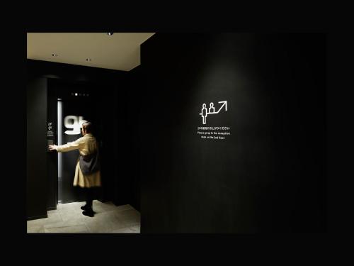 Una donna in piedi in un corridoio che guarda un poster in un museo di 9h nine hours Sendai a Sendai