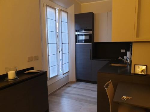 a kitchen with a black counter and a large window at Casa delle Farfalle in Bologna