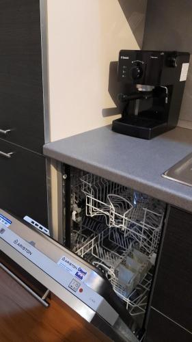 a dishwasher with a coffee maker on top of it at Loft Tirano centro storico - open space Adele in Tirano