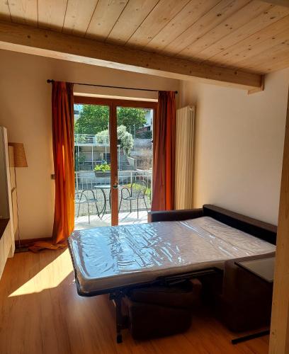 a room with a bed in front of a sliding glass door at Loft Tirano centro storico - open space Adele in Tirano