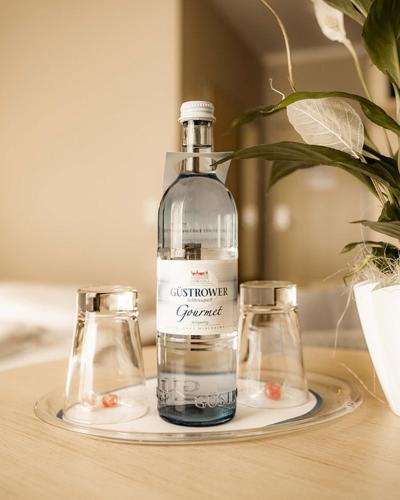 a bottle and two glasses sitting on a table at Müritz-Strandhotel in Röbel