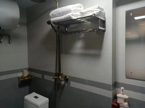 Un baño con un toallero encima del inodoro. en Yijia Xiaozhu, en Hanqiyu