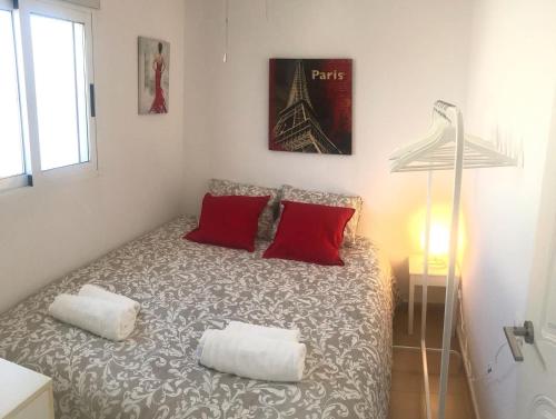 a bedroom with a bed with two red pillows at Villa Corazon in Torrevieja