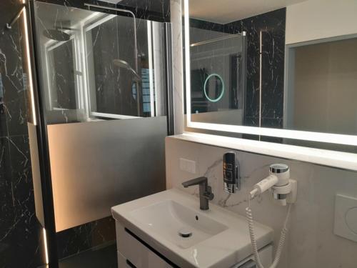 a bathroom with a sink and a mirror at Müritz-Strandhotel in Röbel