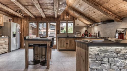 Il comprend une cuisine dotée de plafonds en bois et d'un mur en pierre. dans l'établissement Ferme des Moussoux, à Chamonix-Mont-Blanc