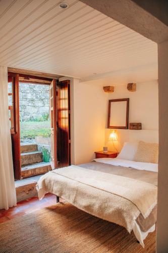 a bedroom with a bed and a large window at Just Like Home - Casa do Cadinho in Viana do Castelo