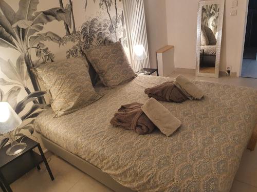 un lit avec deux serviettes et des oreillers dessus dans l'établissement CANNES CALIFORNIE, WINTER PALACE, à 2 pas de la rue d'Antibes et des plages de la Croisette, à Cannes