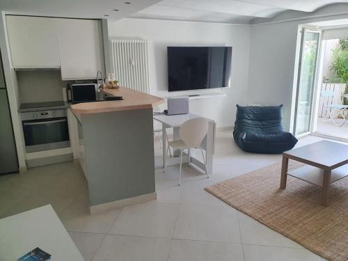 une cuisine et un salon avec une table et un canapé dans l'établissement CANNES CALIFORNIE, WINTER PALACE, à 2 pas de la rue d'Antibes et des plages de la Croisette, à Cannes