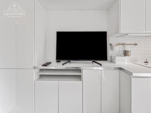 - une télévision au-dessus d'un comptoir blanc dans l'établissement Balcon Montpelliérain proche Fac et Hopitaux, à Montpellier