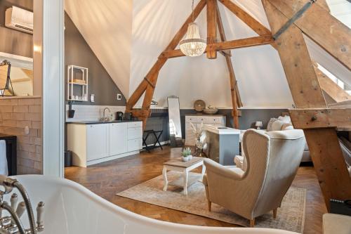 a living room with a bath tub and a kitchen at Boetiekhotel Ons Oude Raadhuis in Hooge Zwaluwe