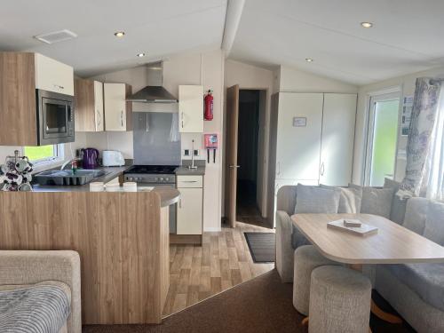 a kitchen and living room with a couch and a table at Red Deer Village Holiday Park - 3 Bedroom, Self-Catering Holiday Home in Steps