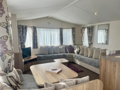 a living room with a couch and a table at Red Deer Village Holiday Park - 3 Bedroom, Self-Catering Holiday Home in Steps