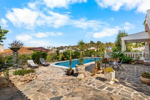a backyard with a swimming pool and a patio with plants at Casa Starlite Sunrise in Almoradí