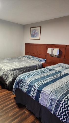 two beds in a hotel room with at Advance Inn in Niagara Falls