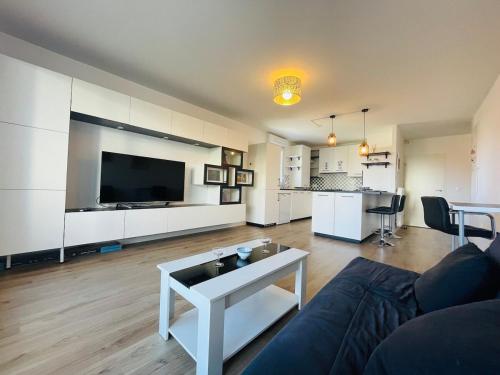 un salon avec un canapé, une télévision et une table dans l'établissement Casa Bella, à Angers