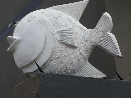 a white statue of a fish on top of a building at CBS Accommodation in Mossel Bay