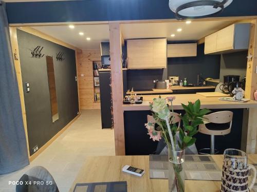 a kitchen with a table with a vase of flowers at loftvesubie Studio in Saint-Martin-Vésubie