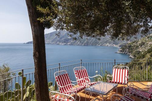 three chairs and a table with a view of the water at Villa Torre in Erchie