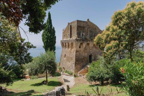 an old castle with the ocean in the background at Villa Torre in Erchie