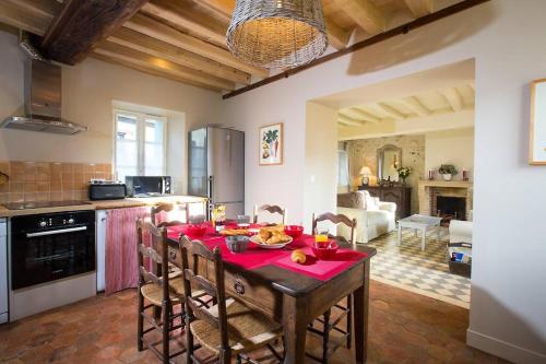 une cuisine avec une table et des chaises dans une pièce dans l'établissement La Maison de Gisèle, à La Villeneuve