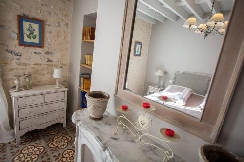 La salle de bains est pourvue d'un miroir, d'une commode et d'un lavabo. dans l'établissement La Maison de Gisèle, à La Villeneuve