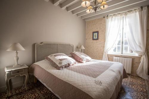 une chambre avec un grand lit et une fenêtre dans l'établissement La Maison de Gisèle, à La Villeneuve