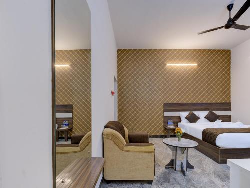 a hotel room with a bed and a chair at Livora Residency in Chennai