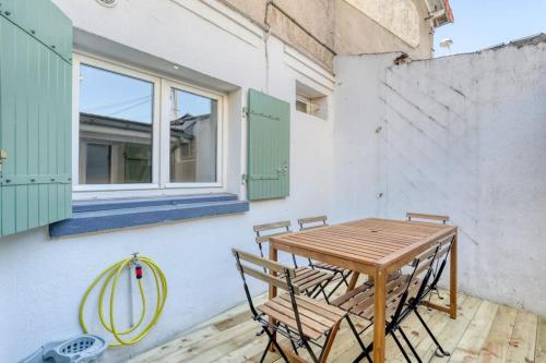 une table et des chaises en bois sur une terrasse avec une fenêtre dans l'établissement Badalux - Paris, CDG, Expo Parc, StadeDeFrance, à Aulnay-sous-Bois