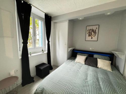 En eller flere senge i et værelse på Joli T2 avec jardin - calme & chaleureux