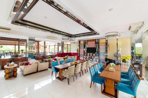 un comedor con sillas y mesas azules en una habitación en Niwa Canting, en Brumbung