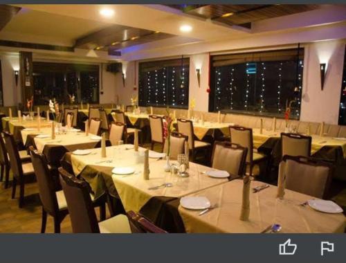 a dining room with tables and chairs and tablesktop at Hotel Baidyanath in Deoghar