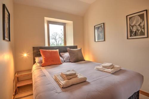 a bedroom with a large bed with two towels on it at Foulis Cottage, Foulis Estate, Highland Scotland in Ardullie