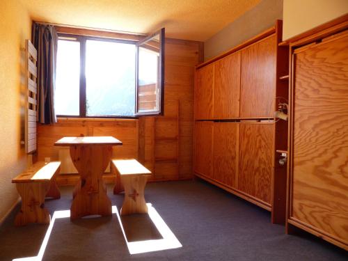 une chambre avec une table, des bancs et une fenêtre dans l'établissement Studio cosy au pied des pistes, près des remontées et commerces - FR-1-557A-34, à La Ferrière