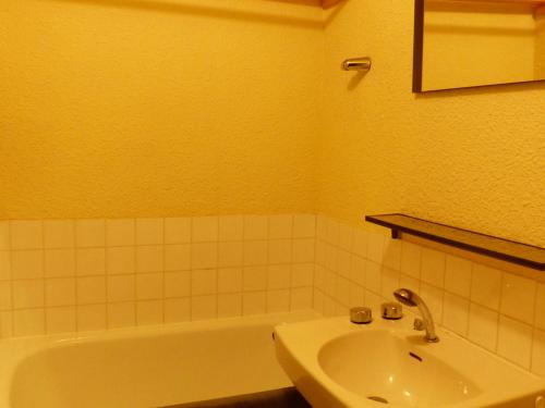 une salle de bain avec un lavabo et une baignoire dans l'établissement Studio cosy au pied des pistes, près des remontées et commerces - FR-1-557A-34, à La Ferrière