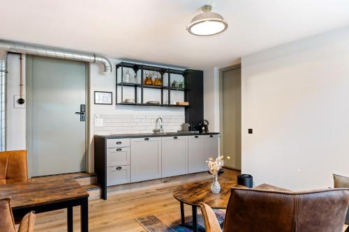 a kitchen with a sink and a table in a room at Boetiekhotel Ons Oude Raadhuis in Hooge Zwaluwe